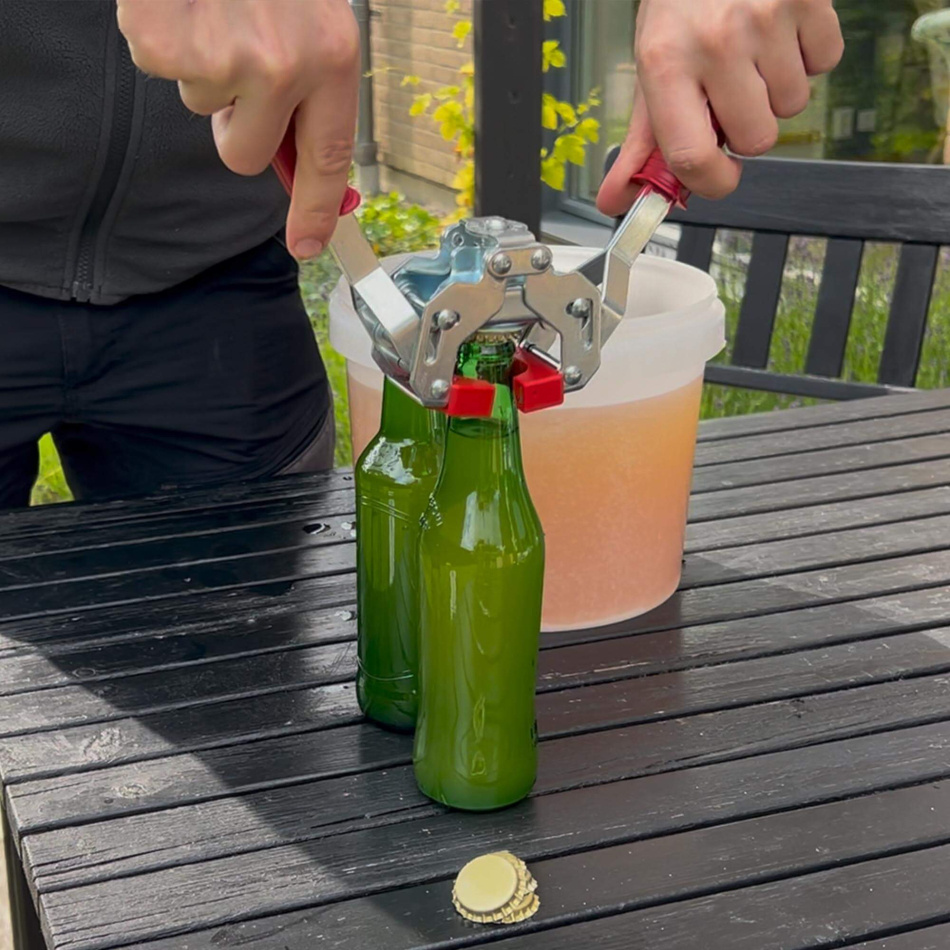 Färdig cider är upphälld på flaska och på bilden monteras kapsylen
